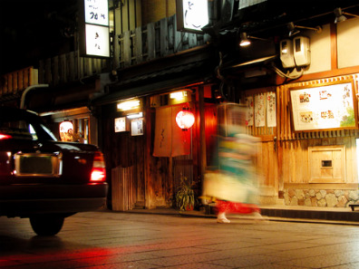 Geisha rushing from a taxi to a tea house in Gion, Kyōto
